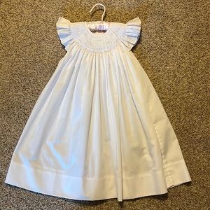 White dress with pink flowers smocked around collar